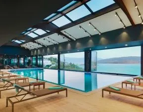 Indoor pool with loungers at Le Méridien Bodrum Beach Resort.