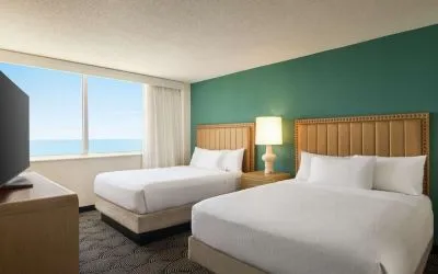 Two queen beds with TV and ocean view at Embassy Suites By Hilton Deerfield Beach Resort & Spa.
