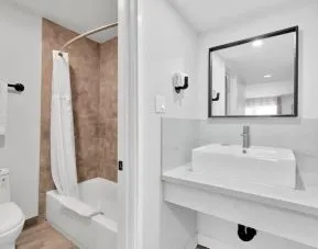 Guest bathroom with shower at Tradewinds Motel.