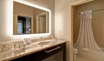 Guest bathroom with shower and tub at Homewood Suites By Hilton Newark-Cranford.