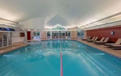 Indoor pool with lounge chairs at Hilton Leicester.