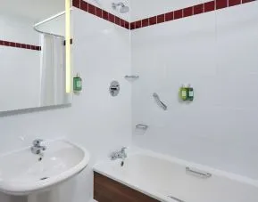 Guest bathroom with shower and tub at Leonardo Hotel Milton Keynes.