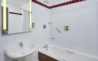 Guest bathroom with shower and tub at Leonardo Hotel Milton Keynes.
