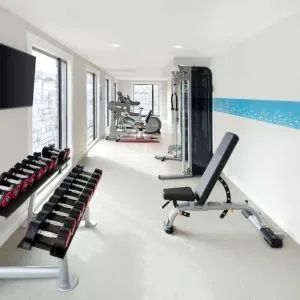 Bright fitness center with machines and equipment at the Hampton by Hilton London Docklands.