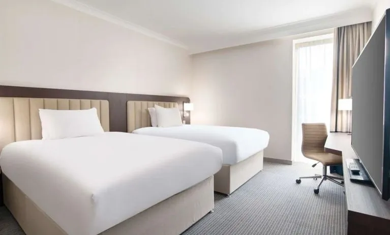 Double guest room with TV screen and desk at the Hilton London Gatwick Airport.