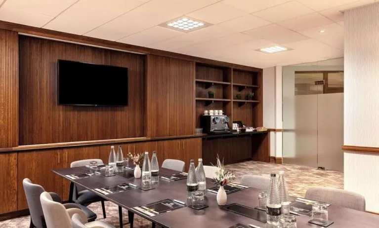 Professional meeting room with TV screen and coffee maker at the Hilton Birmingham Metropole.