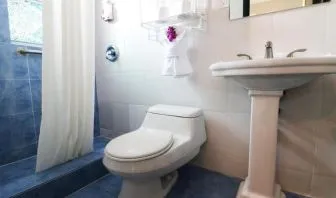 Guest bathroom with shower at Hollywood Beach Suites, A South Beach Group Hotel.