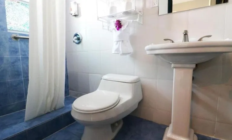 Guest bathroom with shower at Hollywood Beach Suites, A South Beach Group Hotel.