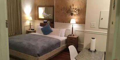 King bed with seating area at Parc Suites Hotel.