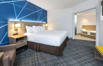 Day use king suite with comfortable bed, sofa and private bathroom with tub at Comfort Inn & Suites Barrie.