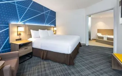 Day use king suite with comfortable bed, sofa and private bathroom with tub at Comfort Inn & Suites Barrie.