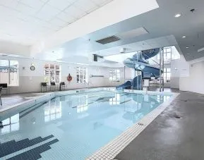 Indoor pool with lounge chairs at Holiday Inn Express & Suites Airport-Calgary.