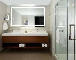 Private guest bathroom with shower and toiletries at DoubleTree By Hilton Montreal Airport.