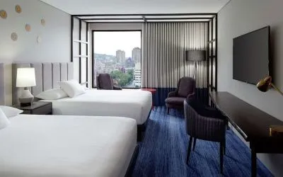 Twin day use room with work desk, lounge area and window view at DoubleTree By Hilton Montreal.
