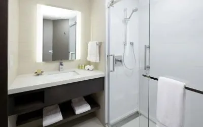 Private guest bathroom with shower and free toiletries at DoubleTree By Hilton Montreal.