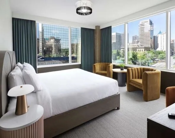 Day use king room with corner city view, work desk and lounge sitting at The Westley Calgary Downtown, Tapestry Collection By Hilton.