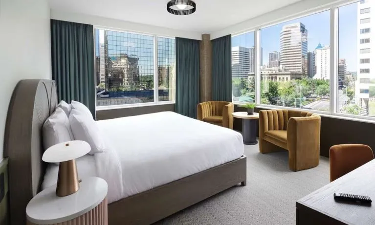Day use king room with corner city view, work desk and lounge sitting at The Westley Calgary Downtown, Tapestry Collection By Hilton.