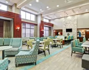 Hotel lounge and dining area with comfortable seating at the  Hampton Inn & Suites By Hilton Guelph.