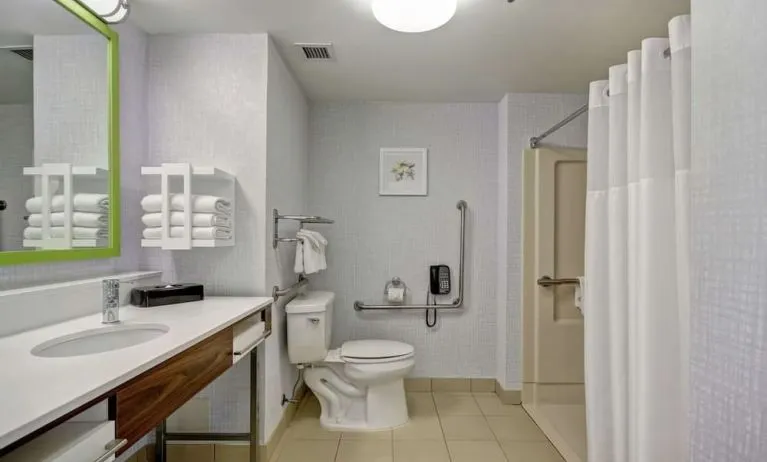 Private guest bathroom with shower and free toiletries at the  Hampton Inn & Suites By Hilton Guelph.