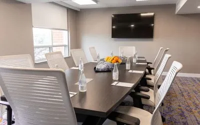 Professional meeting room with TV screen and ergonomic chairs at the Embassy Suites By Hilton Toronto Airport.