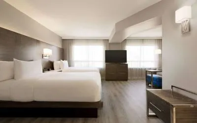 Day use twin room with TV screen, lounge area and work space at the Embassy Suites By Hilton Toronto Airport.