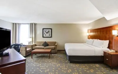 Day use room with TV screen, lounge area, work desk and private bathroom at the Holiday Inn Oakville Centre.