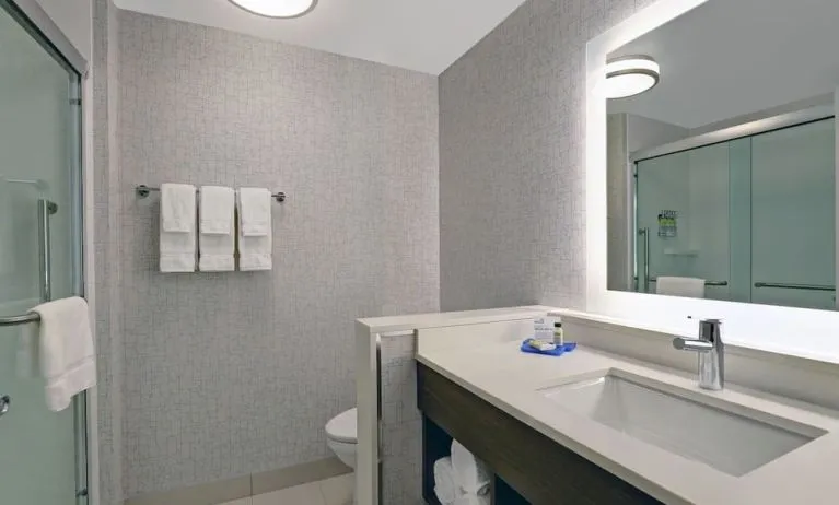 Private guest bathroom with shower and free toiletries at Holiday Inn Express Kingston West.