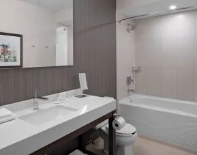 Private guest bathroom with tub and free toiletries at Courtyard By Marriott Edmonton Downtown.