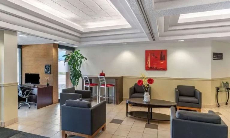 Hotel lobby with lounge area and work station at Quality Hotel & Suites Montreal East.