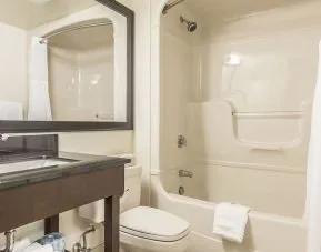 Guest bathroom with tub and free toiletries at Comfort Inn Sept-Iles. 