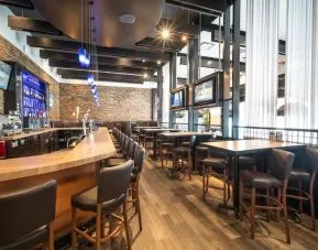 Hotel bar with lounge seating at Acclaim Hotel Calgary Airport.