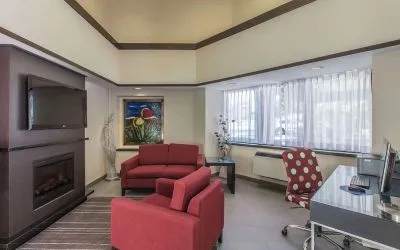 Hotel lobby with fireplace and worskpace with computer and printer at Comfort Inn Corner Brook.