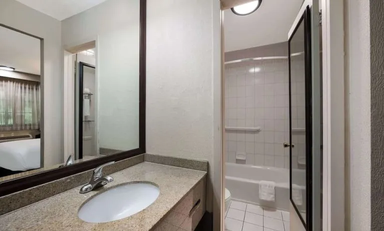 Guest bathroom with shower and tub at Best Western Woodbury Inn.