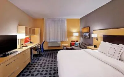 Day use room with TV, work desk and sofa at TownePlace Suites By Marriott London.