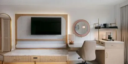 Day use room's workspace with TV screen and workdesk with ergonomic chair at Sonesta Miami Airport.
