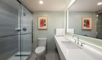 Private guest bathroom with shower and free toiletries at Sonesta Miami Airport.
