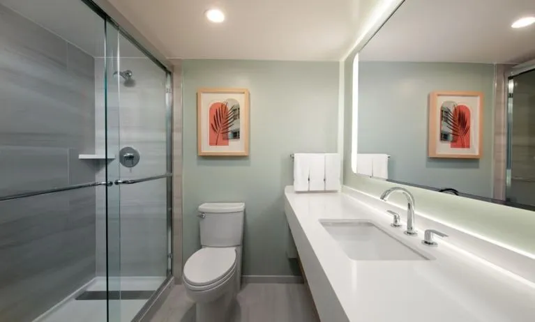 Private guest bathroom with shower and free toiletries at Sonesta Miami Airport.