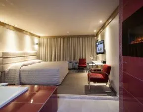 Junior suite with work desk, fireplace and hot tub at Le Chabrol Hotel Et Suites.