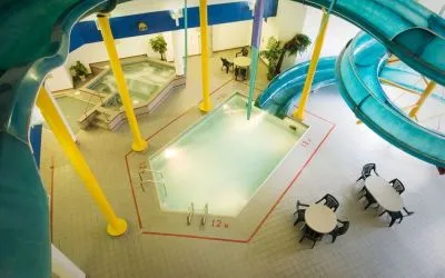 Indoor pool with spiral slide and jacuzzi at Delta Hotel By Marriott Regina.