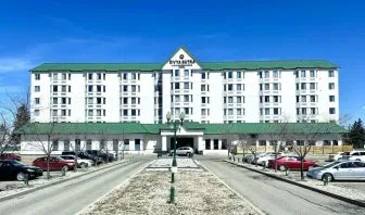 Hotel exterior and parking area at Divya Sutra Plaza & Conference Centre.