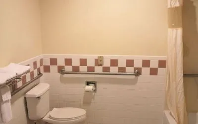 Guest bathroom with shower and tub at Scottish Inn & Suites.