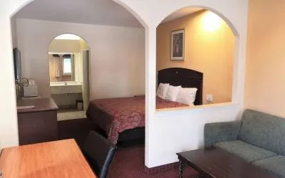 Day use room with sofa and work desk at Scottish Inn & Suites.