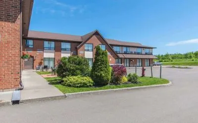 Hotel exterior with lounge seating and parking area at Comfort Inn Moncton Magnetic Hill.