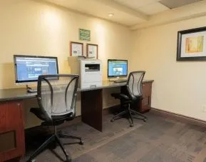 Business center with computers, printer and ergonomic chairs at Les Suites Hotel Ottawa.