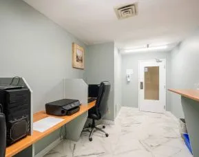 Business center with computers, printer and ergonomic chairs at Halifax Airport Hotel.