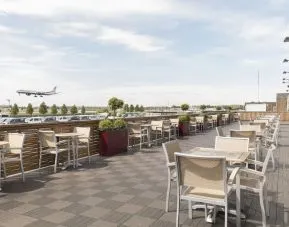Hotel terrace with comfortable seating and airport view at Thistle London Heathrow Terminal 5.