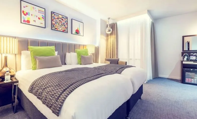 Bright and spacious day use twin room with work desk, sofa, mini bar and coffee maker at Mercure Hotel London Paddington.