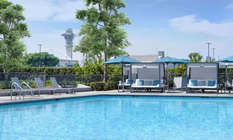 Refreshing outdoor pool with loungers and cabanas at Hyatt Regency Los Angeles International Airport.