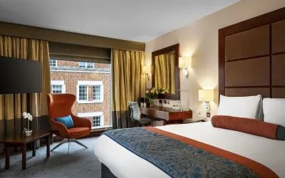 Day use room with work desk, louge seating and floor to ceiling window at Leonardo Royal St Paul's Hotel.