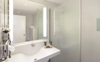 Private guest bathroom with free toiletries at Novotel Manchester West.